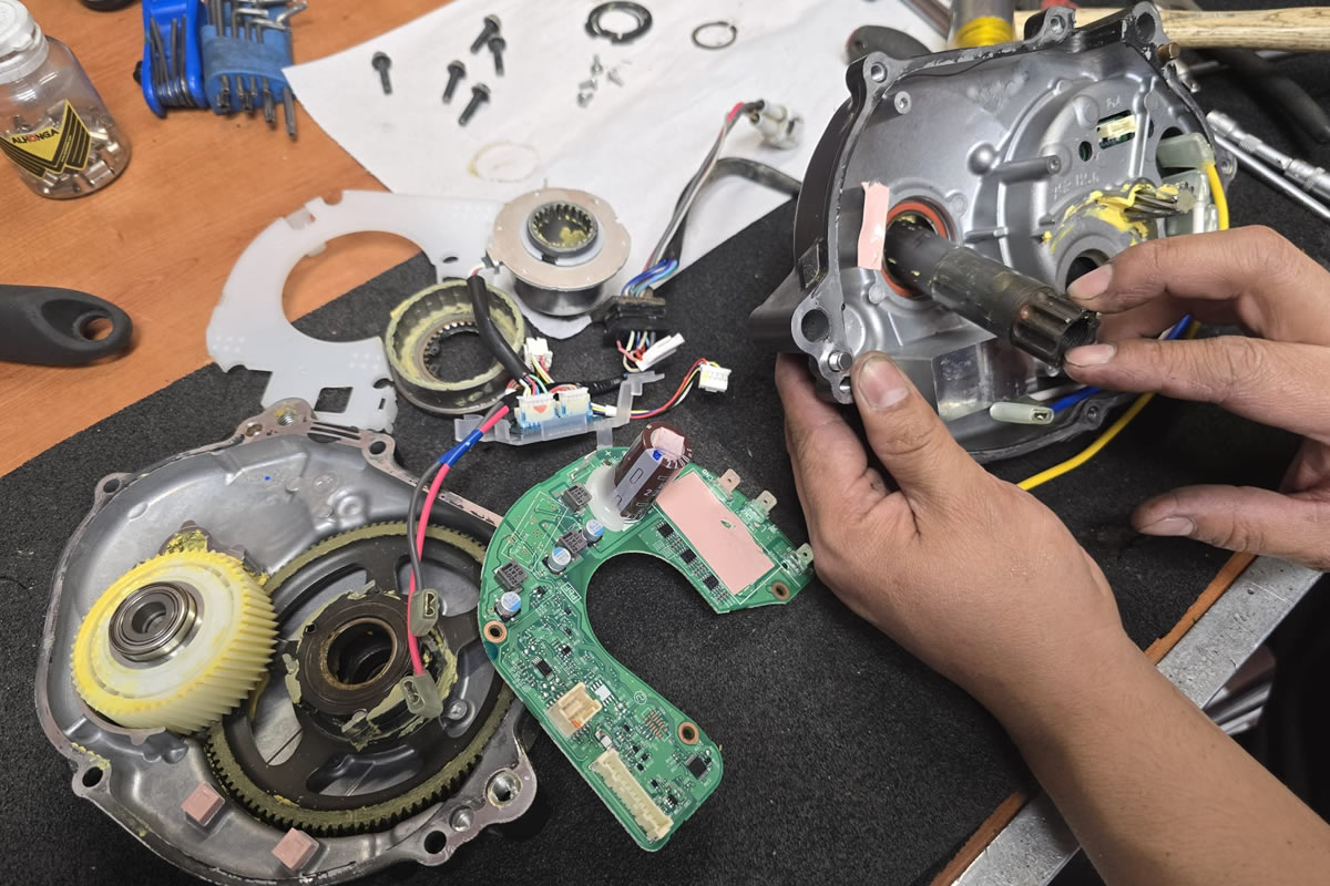Motor de bicicleta eléctrica desmontado en una mesa de trabajo del taller